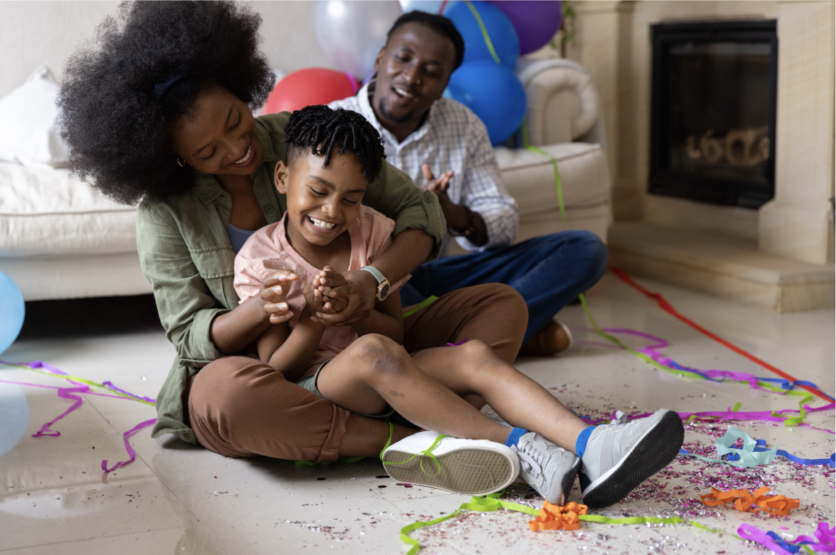 Parents and child laughing together at a birthday celebration